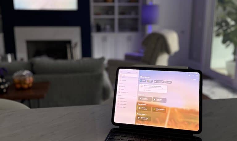 A tablet showcasing a dashboard application sits on a table in a modern living room, offering 10 Smart Home ideas. The space features a sofa, fireplace, and bookshelf, all bathed in soft lighting with a purple glowing lamp adding an extra touch of ambiance.